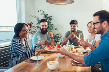 Group Of Happy Young Friends Enjoying Dinner At Home. Group of multiethnic friends enjoying dinner party