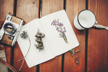 Wall Mural - photo camera, mug, glasses, notebook and wildflowers herbs on wooden background, top view. stylish traveler hipster set flat lay. travel and wanderlust concept