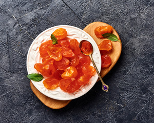 Poster - Dried orange kumquat on black background. Top view of fruits.