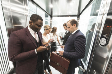 successful and young businessmen in the elevator business center rides to work