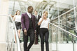 © xartproduction - young businessmen go down the stairs and communicate. African American man and European woman