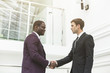 © xartproduction - two young businessmen shake hands