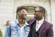 © xartproduction - two young and stylish African American men in the city smiling and talking. father and adult son relationship