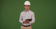 © Mark Adams - Hispanic architect with tablet wearing hard hat helmet on green screen