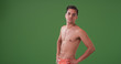 © Mark Adams - Handsome Hispanic man in swim trunks posing on green screen