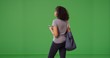 © Mark Adams - Rear view of black woman texting on smartphone on green screen