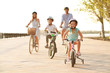 canvas print picture - Happy family riding bicycles outdoors on summer day