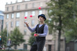 © Anna Jurkovska - A male clown juggles with red balls in the town square