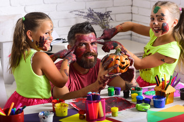 Wall Mural - Halloween Kids or sall girls with bearded man father hold pumpkin.