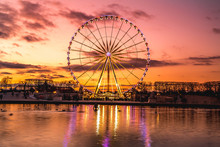 Illuminated Ferris Wheel With Colorful Sunset.
