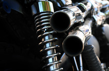 Close Up Rear View Of A Powerful Classic Black Vintage Motorcycle Showing Suspension And Shiny Chrome Exhaust Pipes