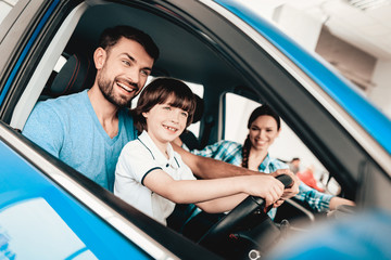 Man With Son Are Sitting At The Wheel Of New Car.