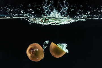 Wall Mural - Splashing kiwi fruit on the water