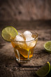 © poplasen - Ice tea in glas served with lime over rustic table