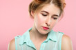 pensive thoughtful mysterious beautiful woman looking down. portrait of a wistful dreamy young girl on pink background.