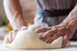 © golubovy - breadmaking recipe. food preparing and culinary skills concept. man hands kneading dough.