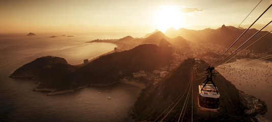 Fototapete - Cable car to sugarloaf mountain and panorama of Rio de Janeiro at sunset
