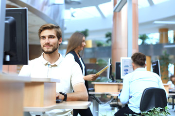 Group of young confident business people analyzing data using computer while spending time in the office.