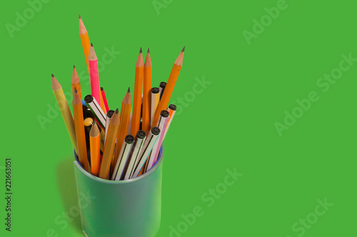 Fotografia, Obraz new bright colored pens and pencils standing in a penholder on a green background