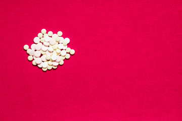 Wall Mural - Medicine pills or capsules on red background