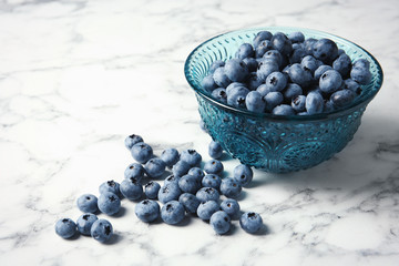 Bowl with fresh blueberries and space for text on marble table