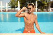 © New Africa - Young man in pool on sunny day