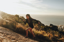 Fit Woman Running Up A Rocky Mountain Trail