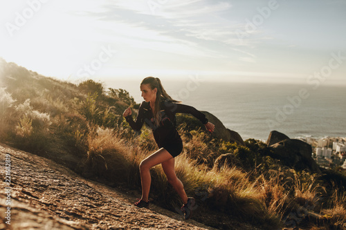 Cuadros en Lienzo Fit woman running up a rocky mountain trail