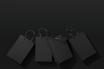 Black shopping bags on black background, Black Friday sale flat lay