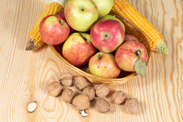 Wall Mural - Basket full of apples beside walnuts and corn combs