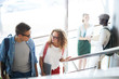 © pressmaster - Young couple in casualwear walking upwards on staircase and having talk while going for lesson