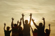Teenage people having fun outdoor. Raising hands up while morning sunrise.