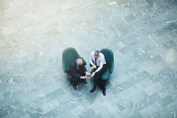 Wall Mural - Mature businessmen using a tablet together in an office lobby