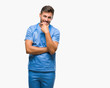 © Krakenimages.com - Young handsome doctor surgeon man over isolated background looking confident at the camera with smile with crossed arms and hand raised on chin. Thinking positive.