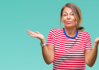 Poster - Middle age senior hispanic woman over isolated background clueless and confused expression with arms and hands raised. Doubt concept.