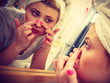 © anetlanda - Woman looking in mirror dealing with acne