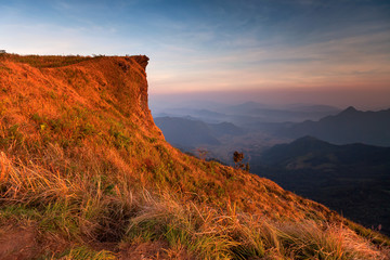 Wall Mural - Sunset scene with the peak of mountain and cloudscape at Phu chi fa in Chiang rai, Thailand