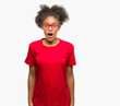 © Krakenimages.com - Young afro american woman wearing glasses over isolated background afraid and shocked with surprise expression, fear and excited face.