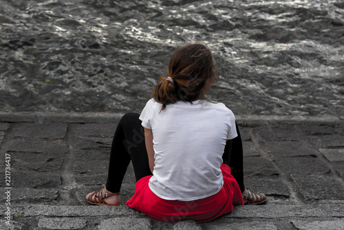 Fotomural Ragazza seduta di spalledi fronte al lago