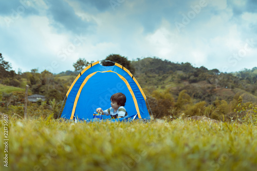 Fotografie, Obraz open shot of a landscape where a child is seen playing inside a tent with the cl