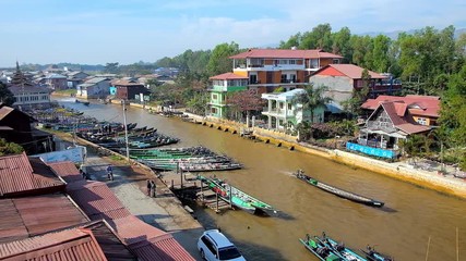 Canvas Print - NYAUNGSHWE, MYANMAR - FEBRUARY 19, 2018: The narrow long canal of Inle Lake with kayak port and small houses and tourist hotels on its banks, on February 19 in Nyaungshwe.