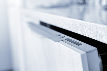 Open dishwasher at the kitchen. Closeup on control panel