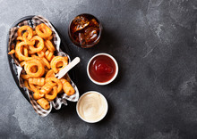 Curly Fries Fast Food Snack In Red Plastic Tray With Glass Of Cola And Ketchup On Stone Kitchen Background. Unhealthy Junk Food