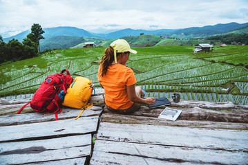 Asian woman travel nature. Travel relax. Standing reading book the balcony of the resort. View of the field on the Moutain in summer. Thailand