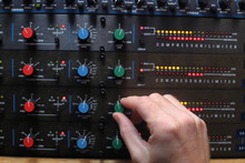 Hands Adjusting Knobs On Sound Compressors Used For Music Production And Broadcast Audio
