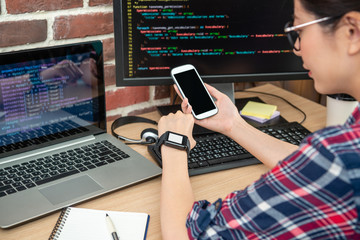 programmer checking phone and smartwatch