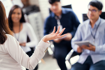 Business woman coach explaining defocused group of people