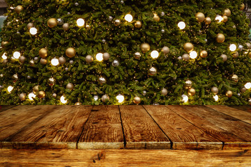 Wall Mural - christmas and new year background with empty wooden deck table over blurred christmas tree at night.