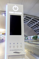 Free battery charging station in the airport for traveler. Phone charging on a table at charging station in the lobby. Free charging on the airport terminal.