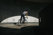 Rückansicht von männlichem Radfahrer, der in einer urbanen Landschaft auf seinem Fahrrad fährt